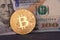 Golden metal bitcoin on dollar bills background. a lot of money in cash. 100 dollars texture. dear bitcoin. Gold coin. Profit from