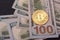 Golden metal bitcoin on dollar bills background. a lot of money in cash. 100 dollars texture. dear bitcoin. Gold coin. Profit from