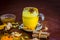 Golden milk or haldi wala dodh with all its dry fruits and spices on wooden surface.