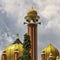 Golden mosque minaret with storm clouds overhead