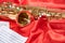 Golden musical instrument alto saxophone on red fabric with music sheets