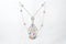 Golden necklace with diamonds on transparent jewelry neck stand in boutique. White gold with diamonds and colorful gemstones,