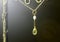 Golden necklace with lemon quartz or yellow quartz with white pearl on black background.