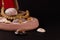 Golden necklace on wooden box with spreaded seashells on dark background