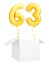 Golden number sixty three inflatable balloon with golden ribbon flying out of blank white box isolated on white