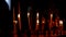 Golden Orthodox the Kanun with burning wax candles on background of dark room