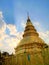 Golden pagoda in Lampang, Thailand, with golden sun ray