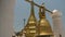 A golden pagoda with a nearby hanging golden bell