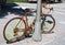 Golden painted bicycle chained to a street lamppost