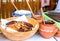 Golden pancakes in a wooden bowl in a rustic style. Toppings for pancakes in ceramic pots