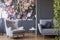 Golden pendant light above a cozy armchair in a fancy living room interior with molding and floral print on gray walls