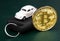 Golden physical bitcoin and car key.