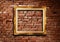 Golden picture frame on grunge brick wall