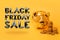 Golden piggy bank with money towers on yellow background with text Black Friday Sale. Stack of euro coins near golden money box.