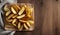 Golden Potato Wedges on Wooden Table with Cloth Backdrop, Copy Space