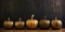 Golden pumpkins in a row on dark background