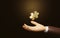 Golden puzzle on businessman`s hand illuminated on dark brown background