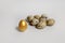 Golden quail egg with ordinary eggs on a white background