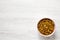 Golden Raisins in a Pink Bowl on a white wooden background, top view. Flat lay, overhead, from above. Copy space