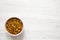 Golden Raisins in a Pink Bowl on a white wooden background, top view. Flat lay, overhead, from above. Copy space