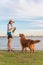 Golden Retriever accompanies its owner on the grass by the sea