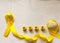 Golden ribbon and words made up of children`s plastic beeches. concept - a symbol of childhood cancer, pediatric oncology