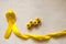Golden ribbon and words made up of children`s plastic beeches. concept - a symbol of childhood cancer, pediatric oncology