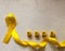 Golden ribbon and words made up of children`s plastic beeches. concept - a symbol of childhood cancer, pediatric oncology