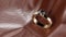 A golden ring with diamonds in studio lighting on maroon leather background.