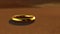 The golden ring lies on a desolate land. A lost piece of jewelry lies on the dirty brown ground in the desert. Generated AI.