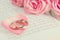 Golden rings on pink rose petal on opened book