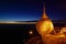 Golden Rock at twilight with praying people, KyaiKhtiyo pagoda,