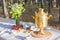 Golden russian samovar with tea cups, snacks on table decorated with some flowers