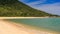 golden sand beach at hill foot with transparent azure sea