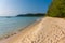 Golden sandy beach of tropical island with forested headland