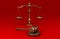 Golden scale and gavel on red solid background