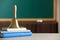 Golden school bell and books on wooden table in classroom, space for text