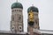 Golden scuplture of Virgin Mary at  Marienplatz with Both onion domes of the Gothic cathedral backgrounds, Munich, Germany