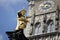 Golden scuplture of Virgin Mary at  Marienplatz with tower clock under blue sky backgrounds, Munich, Germany