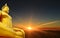 Golden Seated Buddha Image with Amazing Bright Sun Rising on the Sea of Clouds in the Backdrop