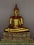 Golden seated Buddha on pedestal