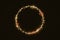 Golden shimmering circle of glittering particles on black background, copy space