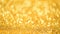 Golden shiny background for Christmas greetings. Banner with defocused lights, bright yellow bokeh. Shimmer of gold