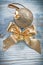 Golden shiny Christmas ball bow on wooden board holidays concept