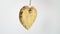 Golden shiny decorative shining heart on a white background.