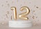 Golden shiny number twelve on beige, neutral background with falling down confetti. Symbol 12. Invitation for a twelfth