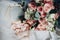 Golden shiny wedding rings lie in a decorative box next to a wedding bouquet