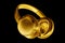 Golden shiny wireless headphones on black background isolated close up, luxury gold metal bluetooth headset, yellow earphones