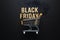 Golden shopping cart on dark background, Black Friday concept