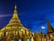 The golden Shwedagon Pagoda in Yangon formerly Rangoon is dramatically illuminated in front of the deep blue twilight sky, in